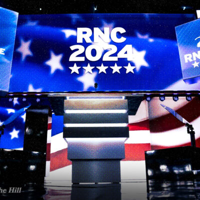 Stage with RNC 2024 logos, Milwaukee outline, elephant symbol, and American flag backdrop. Text credits The Hill.